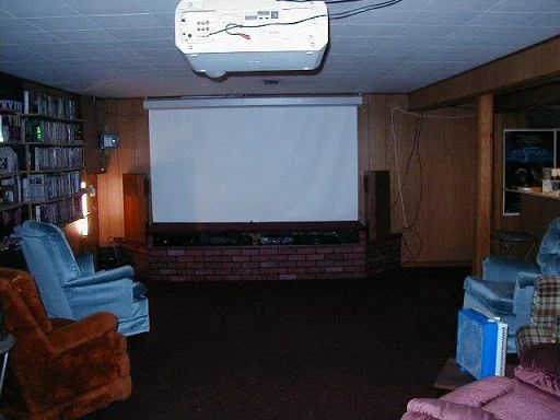 Unfinished room with a theater and a bar section washer and dryer and a living area.